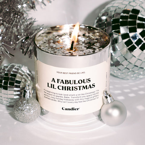 A christmas themed candle topped with silver glitter and a label that reads A fabulous little Christmas