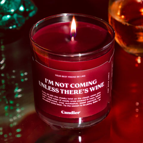 Festive red scented candle with a label that reads I'm Not Coming Unless There's Wine