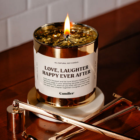 a metallic gold wedding candle with a label that reads Love Laughter Happy Ever After