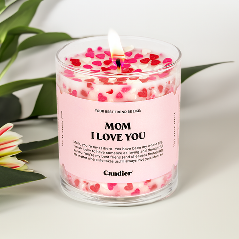 A candle with red and pink heart shaped sprinkles and a label that reads Mom I Love you