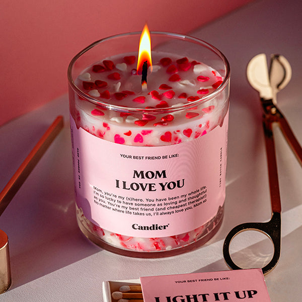 A candle with heart shaped sprinkles and a label that reads Mom I Love You