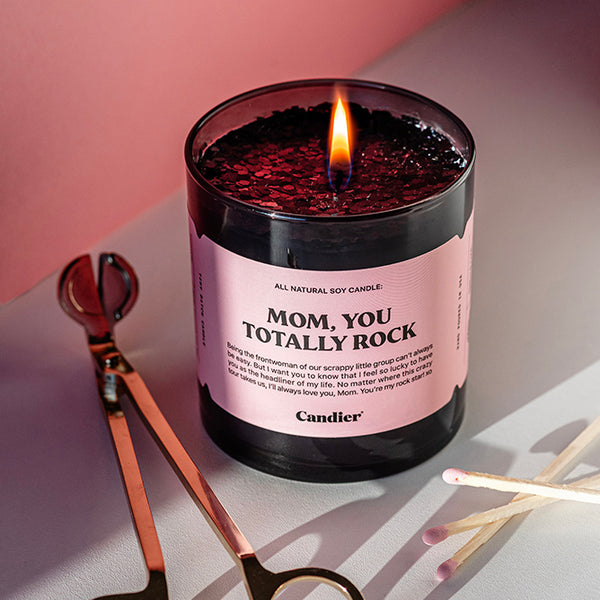 A black candle with sparkling black glitter and a label that reads Mom, You Totally Rock