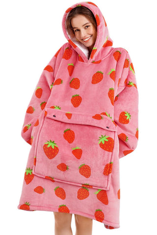 Cute young woman wearing oversized pink hoodie patterned with red strawberries