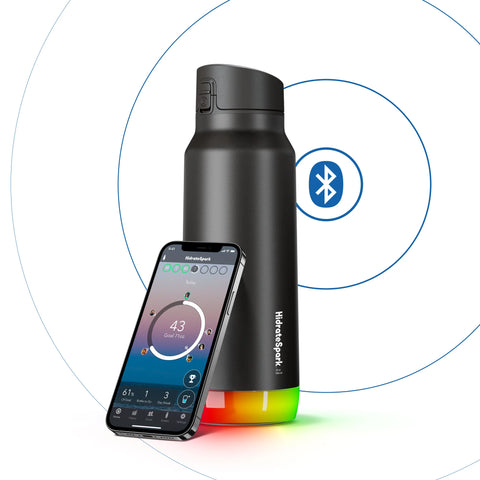 A black smart water bottle beside an iPhone