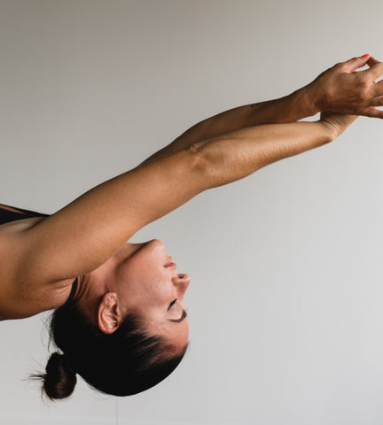 Woman doing yoga in her evening daily health and wellness routine.