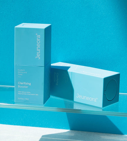 Clarifying Booster serum sitting on blue bathroom shelf for evening skincare routine