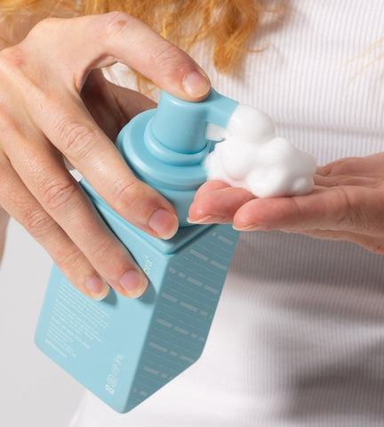 Woman pumping gentle foaming face cleanser onto the back of her hand