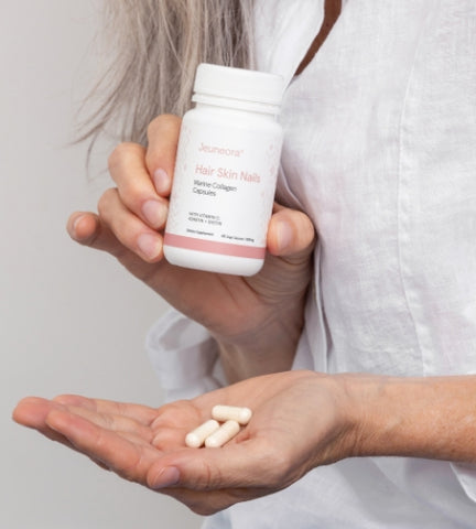 Woman holding Marine Collagen capsules in hand and packaging.