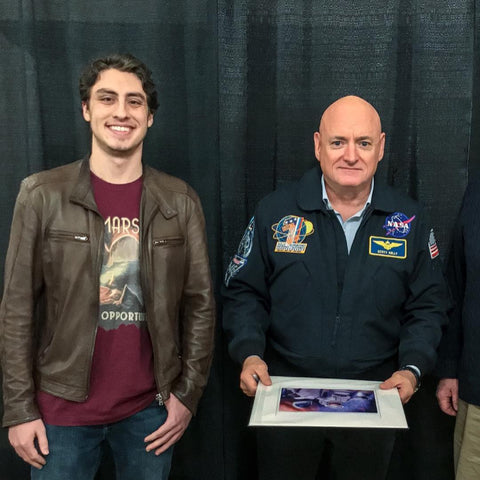 Astronaut Scott Kelly posing with me, Peter DeLuce, for a picture. He is holding one of my art prints that I gave him as a gift.