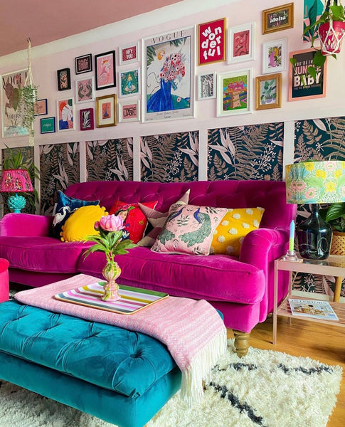 living room with print clash and gallery wall over a pink velvet sofa