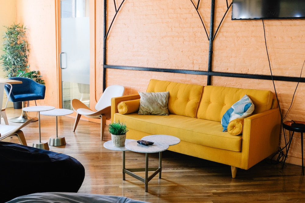 Sunbaked interior with yellow sofa and living coral walls