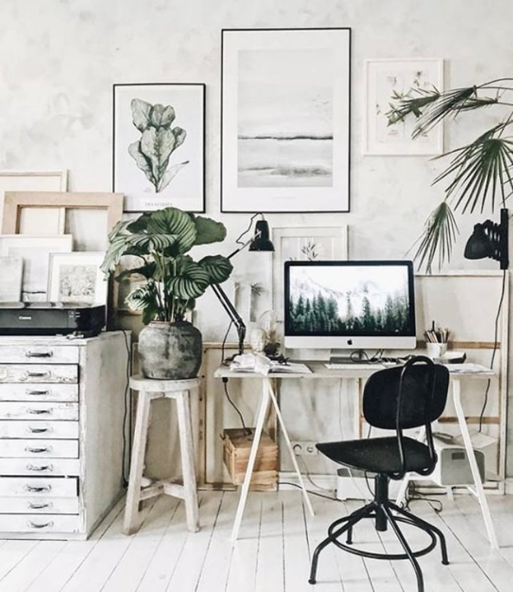 scandi style home office set up with a desk, computer, chair and filing cabinet. Wall art and house plants create a calming productive space
