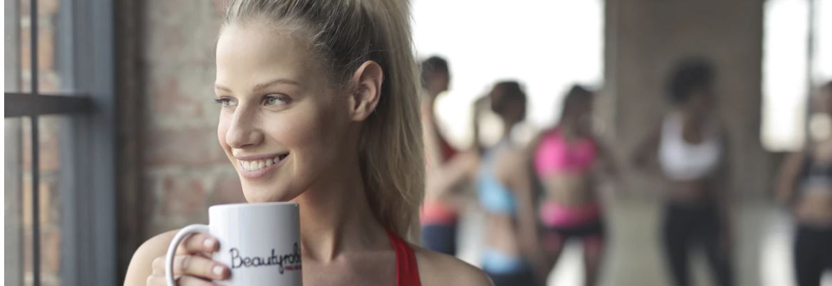 Woman drinking herbalife nutrition tea during her sports session