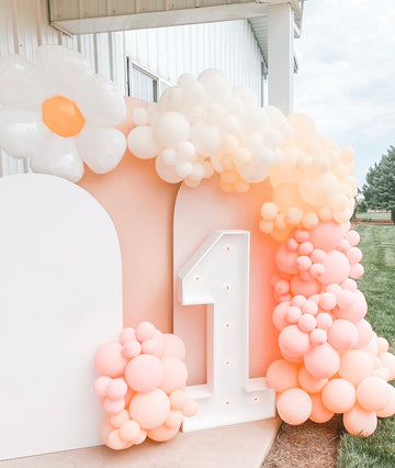 The number 1 marquee under a balloon pink, gold, and white, arch 