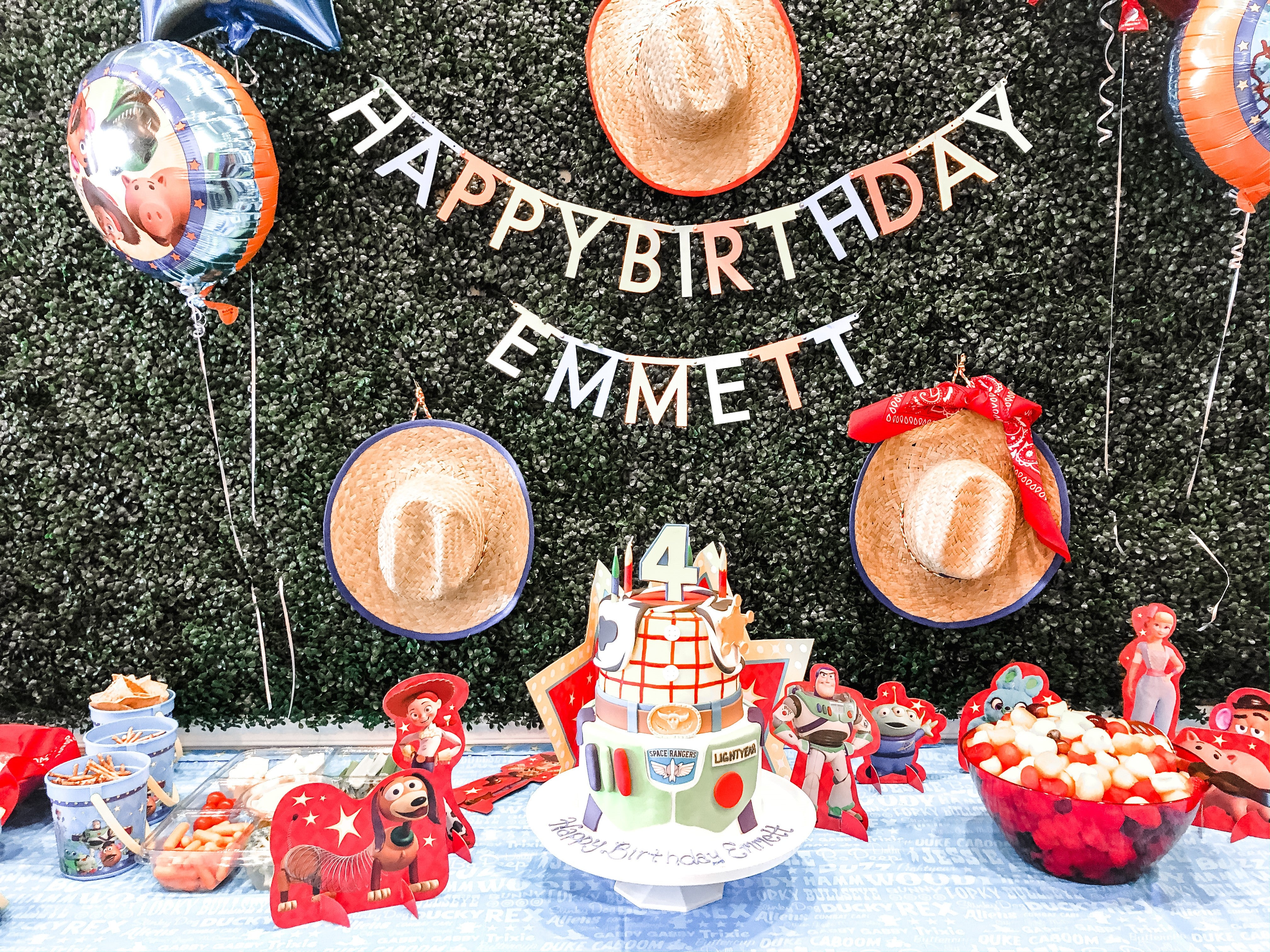 A Toy Story theme birthday party with a banner, cake, balloons, and decorations