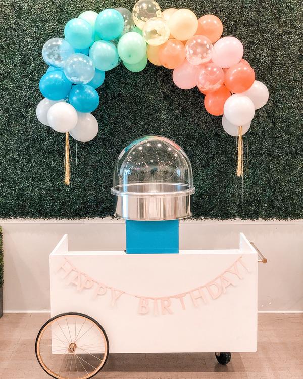 The cotton candy machine under a balloon garland at Waterlemon