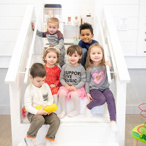 A group of kids sitting on the stairs of the play house in Waterlemon Kids