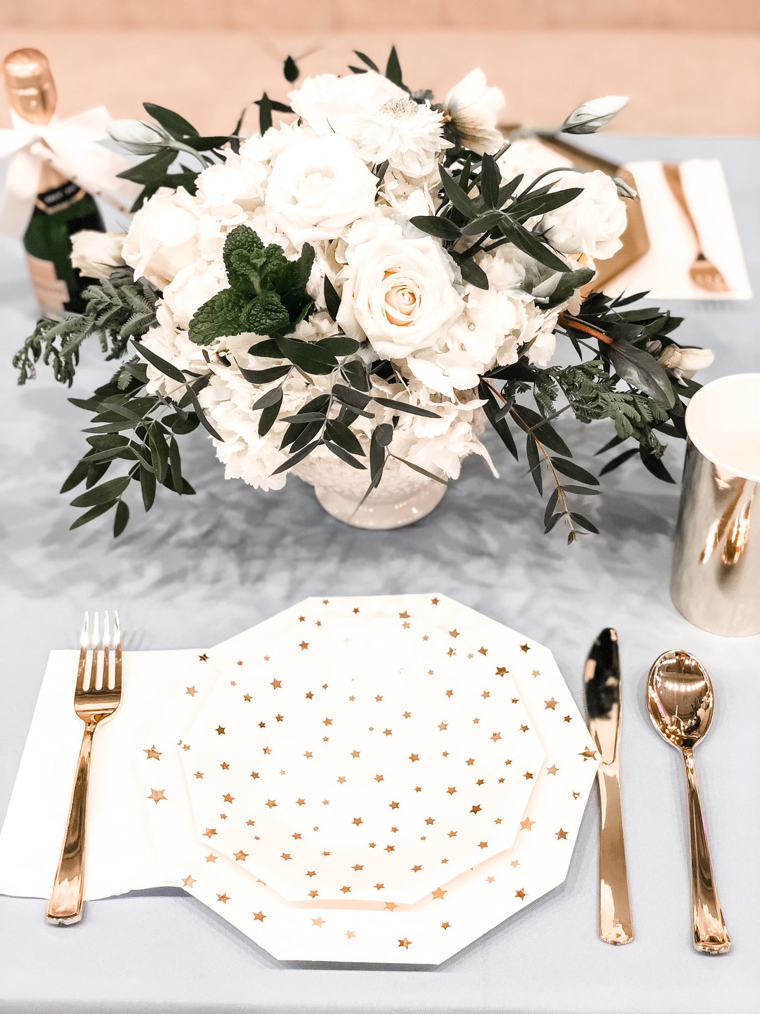 A gold and white table setting for a baby shower