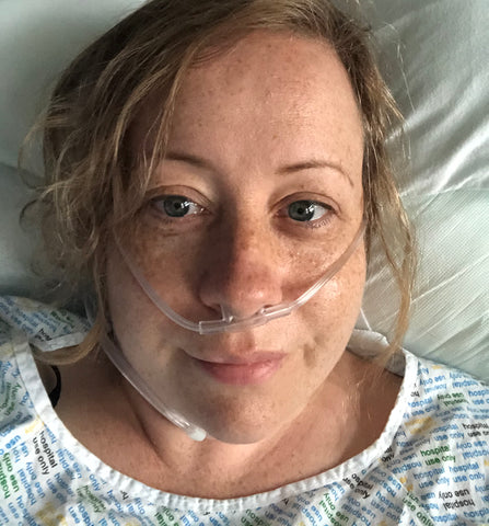 Mhairi, white female, lies in bed on oxygen after Endometriosis operation
