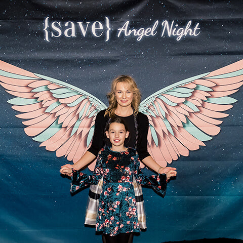 mother and daughter in front of wings backdrop at Save Angel Night on Instagram