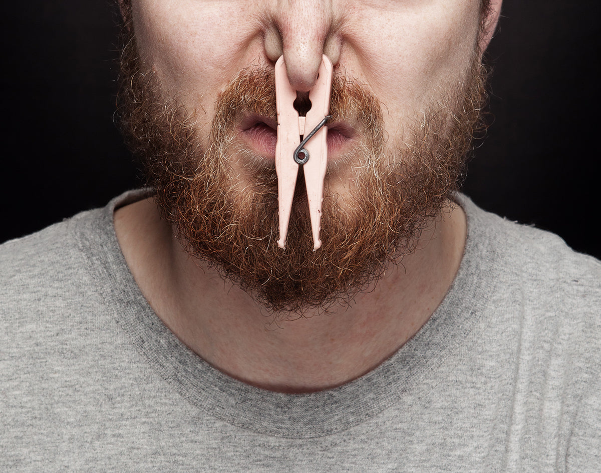 Man With Clothespin Clamping Nose Shut | Marijuana Packaging