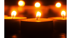 The image depicts a close-up view of tealight candles with a warm, golden glow