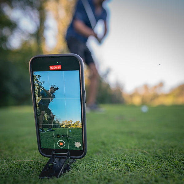 A pocket tripod holding an iphone while taking a video of someone who plays golf