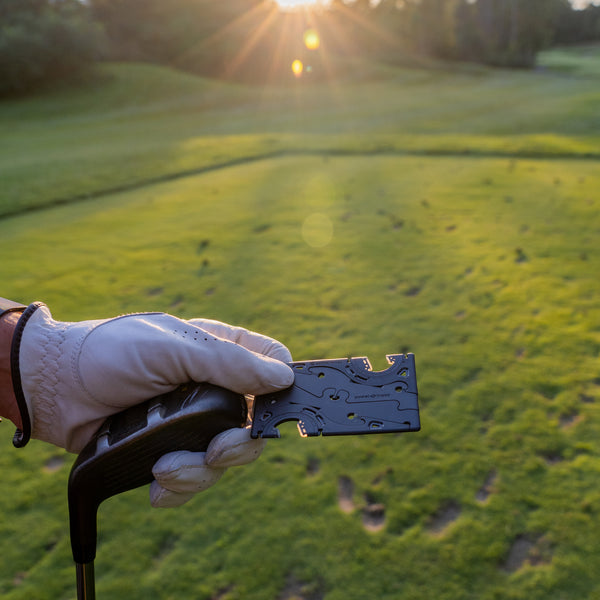 A hand carrying a pocket tripod and a golf stick