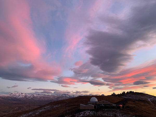 Morning landscape with pink and red sky with an observatory and mountains on the background