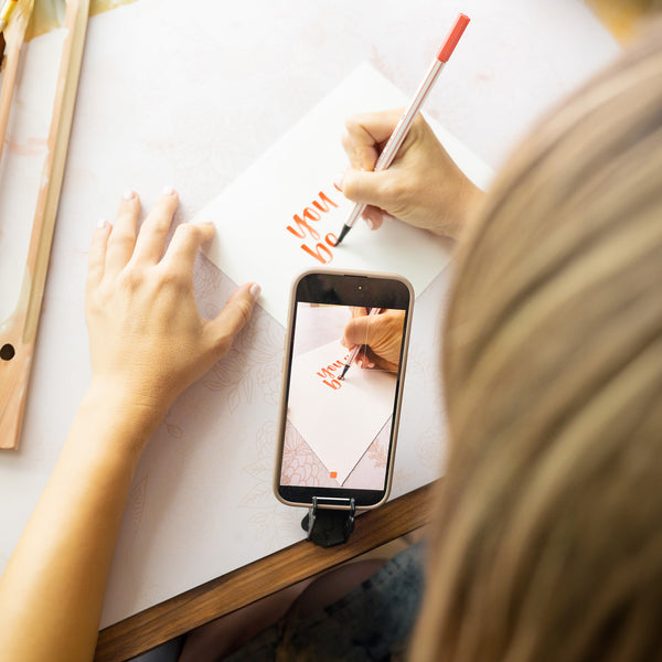 An iPhone taking a video of someone drawing