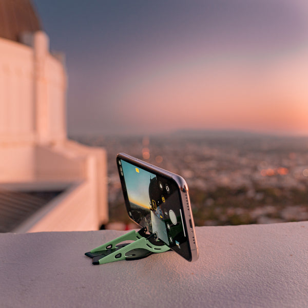 An iphone on a tripod taking a photo of a landscape from a rooftop