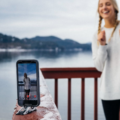 A girl vlogging outdoor in front of her iphone on a tripod