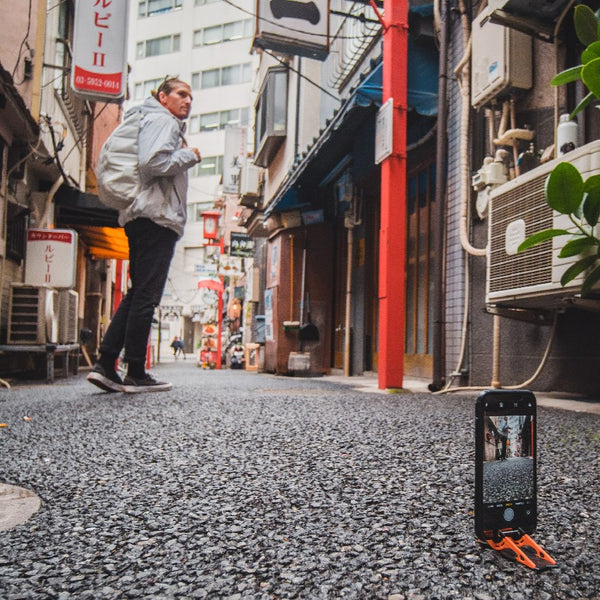 An iphone on a tripod taking a picture of a guy from a low angle in Japan