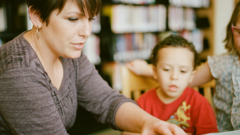 Woman teaching young children in a library