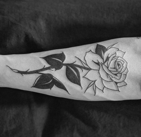 Black rose tattoo on the shoulder blade