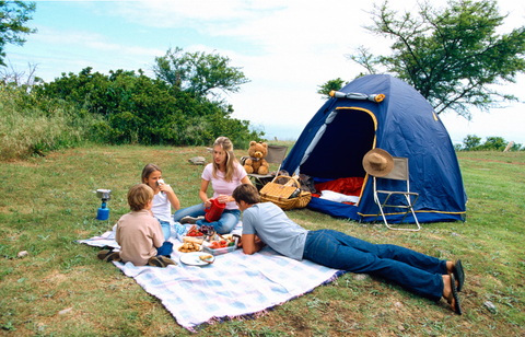 Family having a picnic outside a blue tent