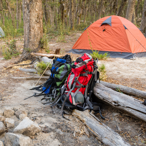 two rucksacks outside an orange tent