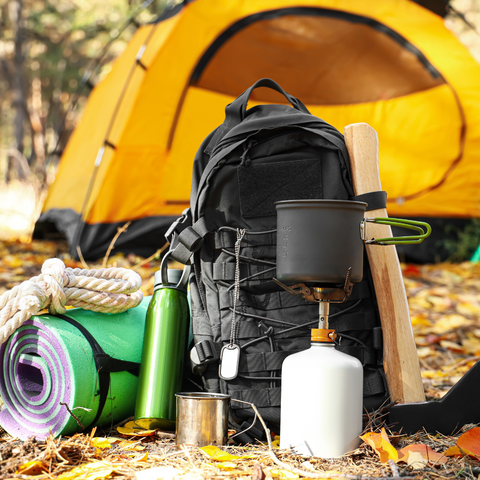 camping gear and rucksack outside yellow tent
