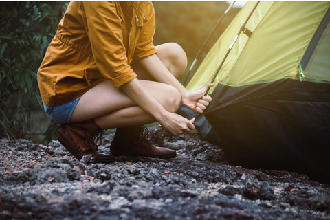 Woman secures tent into ground