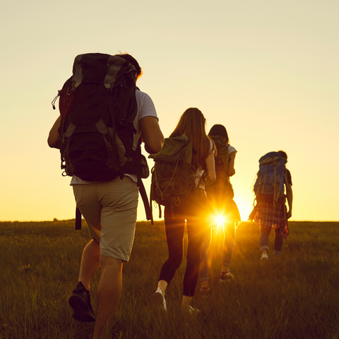 friends backpack across field