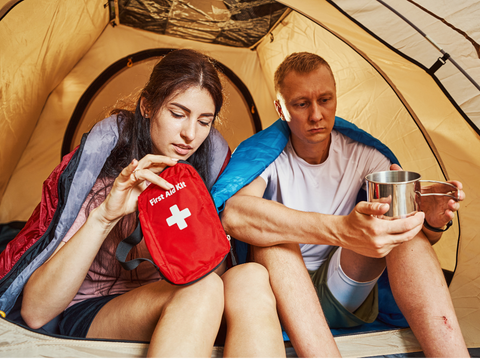 Couple in a tent with a first aid kit