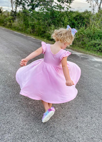 child twirling in blush pink twirl dress