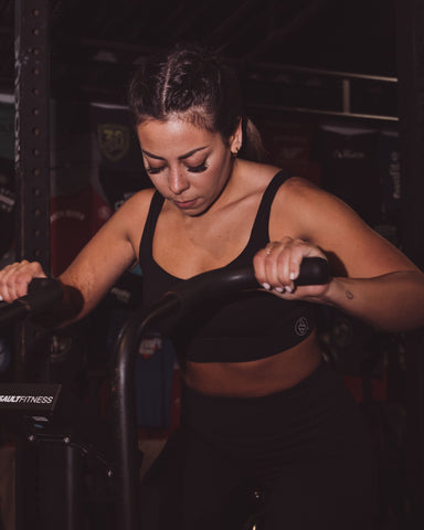 Femme brassière noire sur velo elliptique