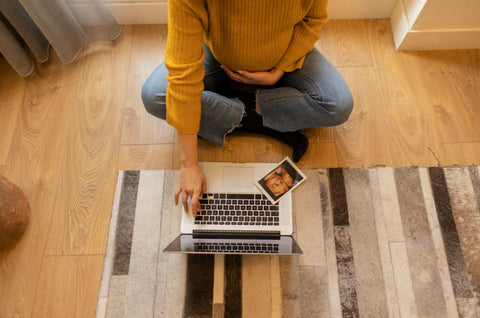 pregnant woman sitting on the floor in front of computer