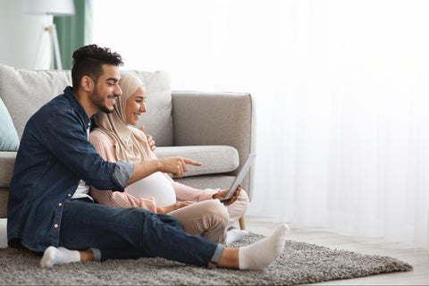 couple smiling in front of laptop