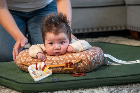 Baby using tummy time pillow with parent supervision