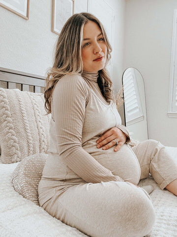 pregnant woman sitting on bed