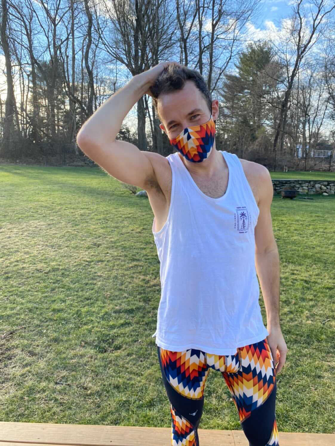 Man stretching while wearing multi-colored compression leggings