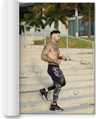 tattooed man jogging down a set of stairs while wearing black leggings