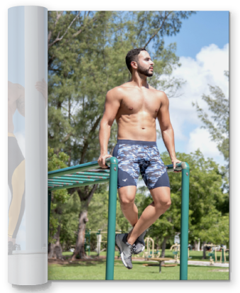 muscular man in compression shorts sitting on top of monkey bars